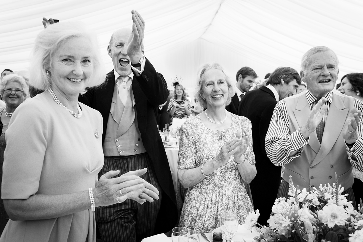 guests applaud arrival of bride & groom black & white summer wedding photography Ovington Hampshire