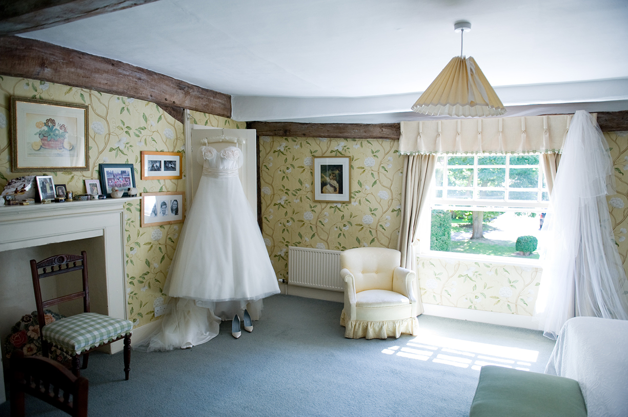 Philippa Lepley wedding dress hangs in bedroom hot sunny wedding Braintree Essex